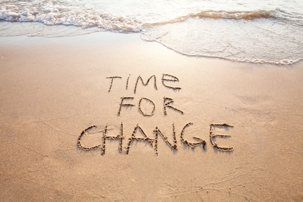 sand, ebbing water and the phrase "Time For Change" etched in the samd