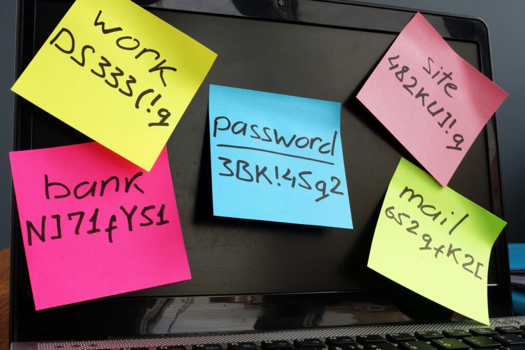 Laptop with password post-it notes all over it.